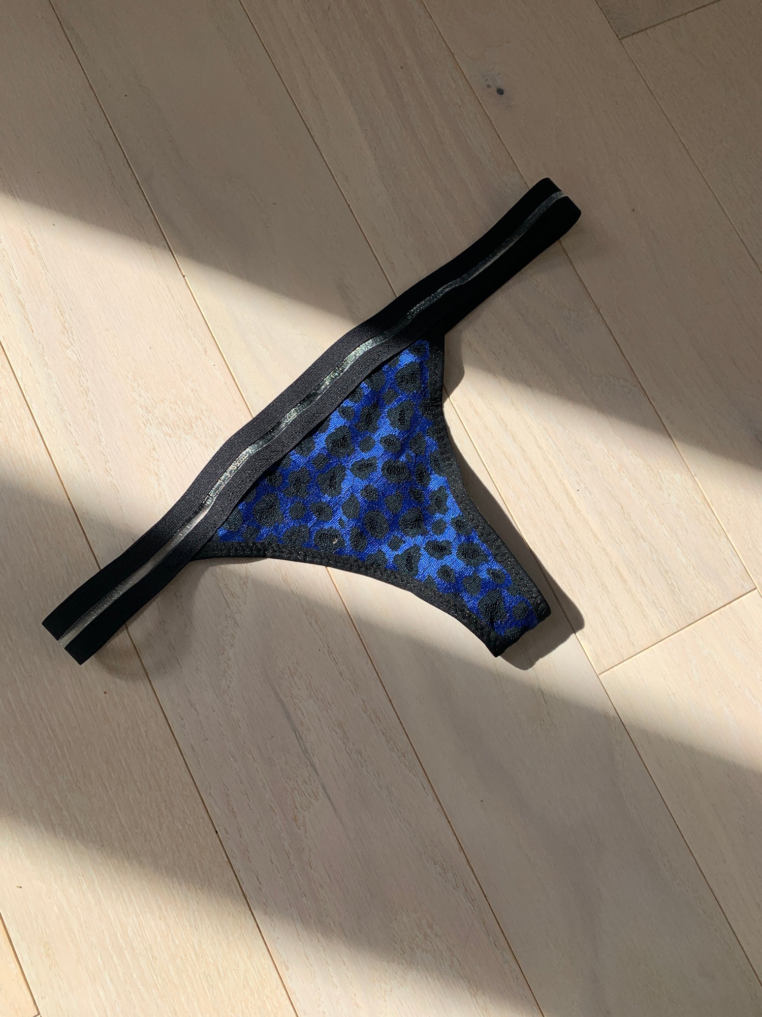 blue and black leopard undies against a wooden floor