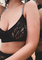 girl posing in black bra from the neck down